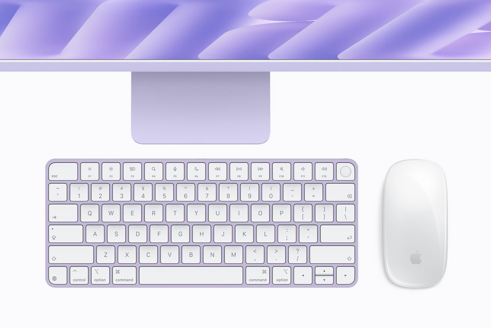 Paarse iMac van bovenaf gezien, met een wit-paars toetsenbord en een muis in dezelfde kleur