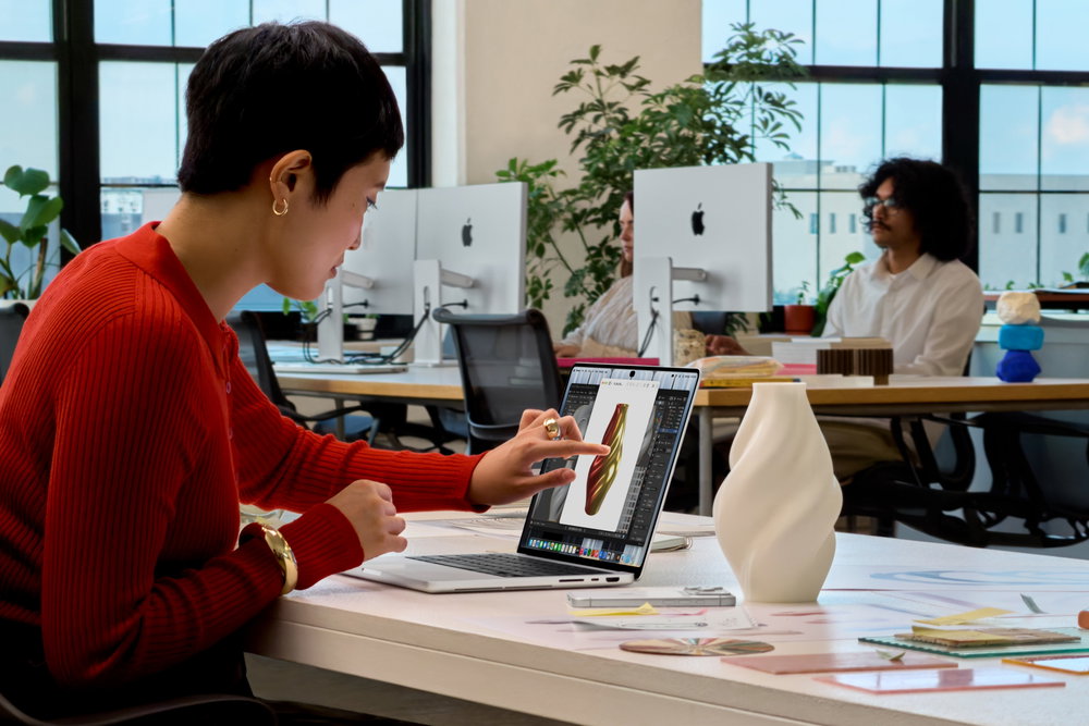 Het aanraakscherm gebruiken op de MacBook Pro tijdens het werken aan een bureau.