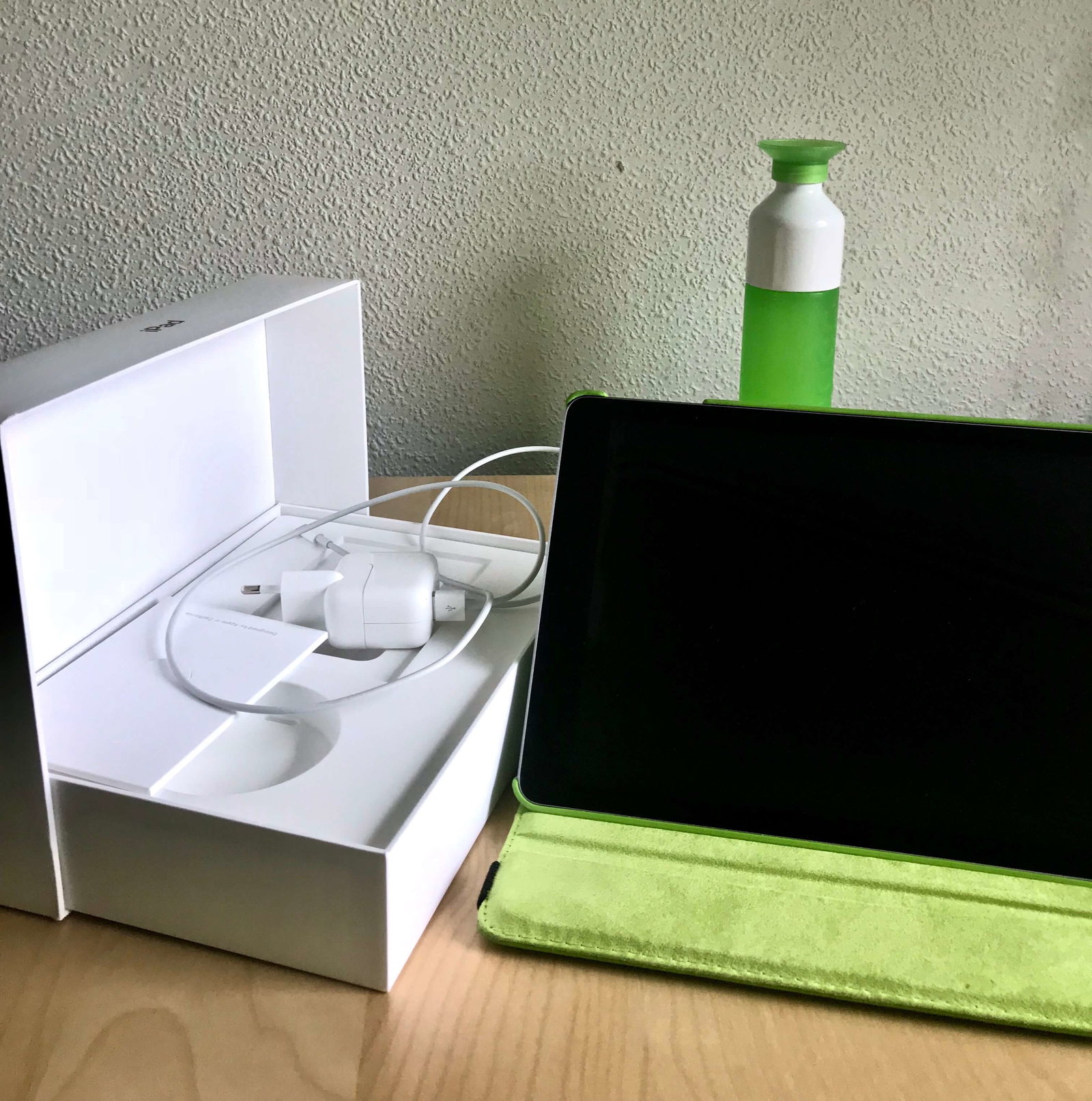 Een foto van een tweedehands iPad op een neutrale achtergrond. Met doos, boekje en lader duidelijk zichtbaar